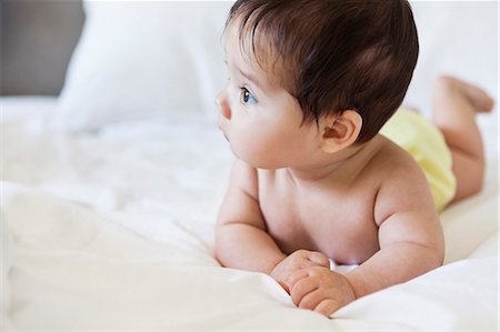 Baby girl laying on bed Foto de stock - Sin royalties Premium, Código: 6113-07542387