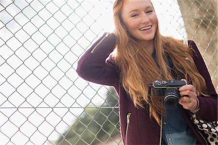 people looking up at camera - Woman holding camera outdoors Stock Photo - Premium Royalty-Free, Code: 6113-07542452