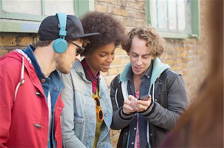 entertainment - Friends using cell phone on city street Stock Photo - Premium Royalty-Free, Code: 6113-07542463