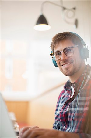 Man wearing headphones and using laptop Photographie de stock - Premium Libres de Droits, Code: 6113-07542460