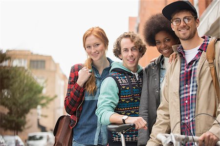 Friends smiling together on city street Stock Photo - Premium Royalty-Free, Code: 6113-07542486