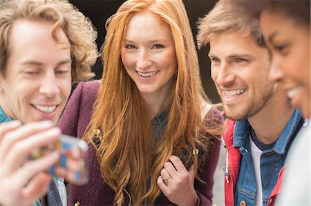 people hanging out - Friends taking self-portrait with camera phone outdoors Stock Photo - Premium Royalty-Free, Code: 6113-07542499