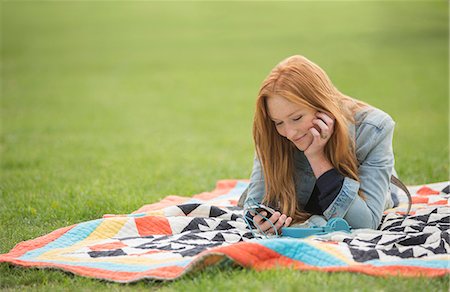 simsearch:6113-08220498,k - Woman using cell phone on blanket in park Stock Photo - Premium Royalty-Free, Code: 6113-07542502