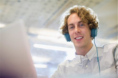 Businessman listening to headphones in office Stock Photo - Premium Royalty-Free, Code: 6113-07542536