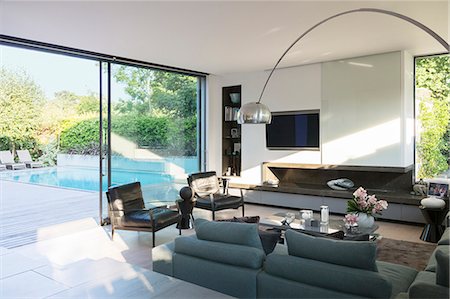 simsearch:6113-07147603,k - Modern living room overlooking patio with swimming pool Foto de stock - Sin royalties Premium, Código: 6113-07542672