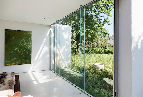 Modern house with glass walls overlooking grass Photographie de stock - Premium Libres de Droits, Le code de l’image : 6113-07542730