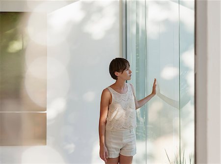 reflection in glass - Pensive woman standing at sunny window Stock Photo - Premium Royalty-Free, Code: 6113-07542739