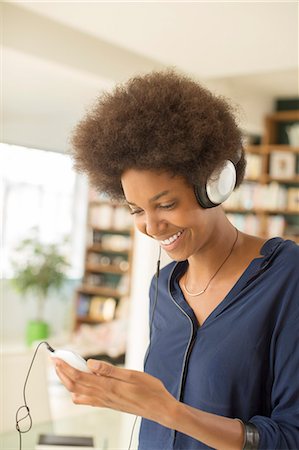 simsearch:6113-07542850,k - Woman listening to headphones in living room Photographie de stock - Premium Libres de Droits, Code: 6113-07542848