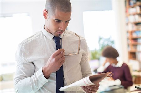 eyeglasses and newspaper - Businessman reading newspaper in living room Stock Photo - Premium Royalty-Free, Code: 6113-07542896