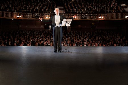 Conductor performing on stage in theater Photographie de stock - Premium Libres de Droits, Code: 6113-07542916