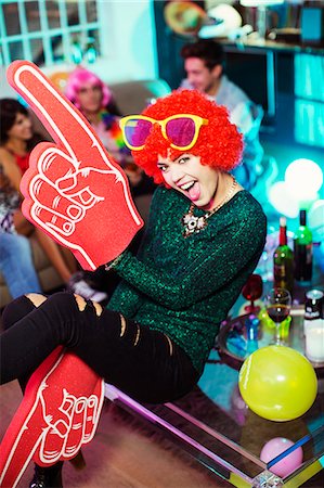 funny happy adult portrait - Woman wearing wig, oversized sunglasses and foam finger Stock Photo - Premium Royalty-Free, Code: 6113-07543049