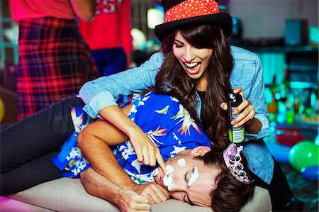 party in lounge - Woman spraying shaving cream on sleeping man's face at party Stock Photo - Premium Royalty-Free, Code: 6113-07543072