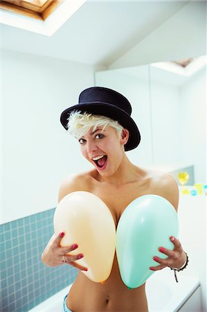 Woman covering breasts with balloons Stock Photo - Premium Royalty-Free, Code: 6113-07543006