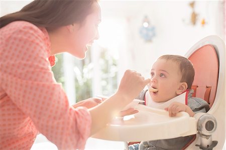 simsearch:6113-07543195,k - Mother feeding baby boy in high chair Foto de stock - Sin royalties Premium, Código: 6113-07543155