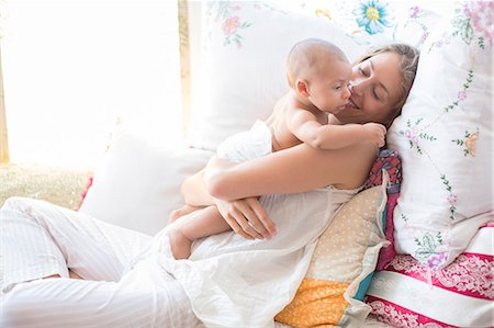 people embracing - Mother holding baby boy on bed Stock Photo - Premium Royalty-Free, Code: 6113-07543184