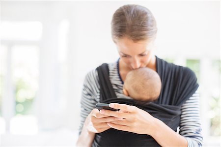 Mother with baby boy using cell phone Stock Photo - Premium Royalty-Free, Code: 6113-07543242