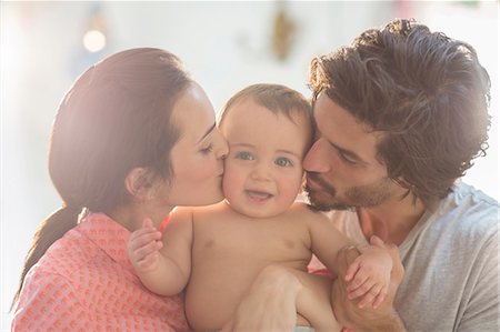 smiling baby - Parents kissing baby boy's cheeks Stock Photo - Premium Royalty-Free, Code: 6113-07543254