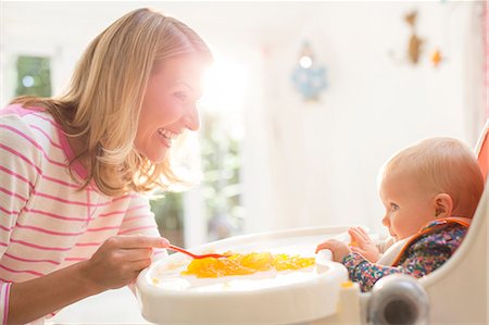 selective focus - Mother feeding baby girl in high chair Stock Photo - Premium Royalty-Free, Code: 6113-07543224