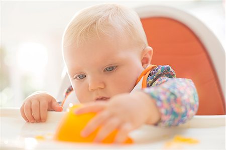 Baby girl playing with gelatin dessert in high chair Stock Photo - Premium Royalty-Free, Code: 6113-07543226