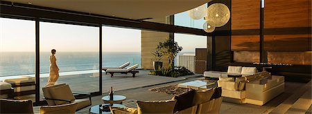 Woman walking on modern patio overlooking ocean Photographie de stock - Premium Libres de Droits, Code: 6113-07543300