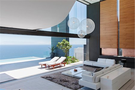 simsearch:6113-07543354,k - Living room and patio of modern house overlooking ocean Foto de stock - Sin royalties Premium, Código: 6113-07543335