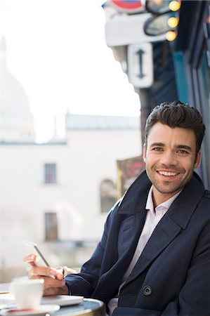 stubble - Businessman using cell phone at sidewalk cafe Stock Photo - Premium Royalty-Free, Code: 6113-07543463