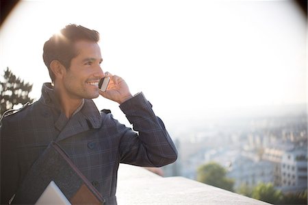 dialog - Businessman on cell phone overlooking city Stock Photo - Premium Royalty-Free, Code: 6113-07543465