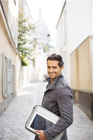 eye contact - Businessman carrying digital tablet on city street Stock Photo - Premium Royalty-Free, Code: 6113-07543466