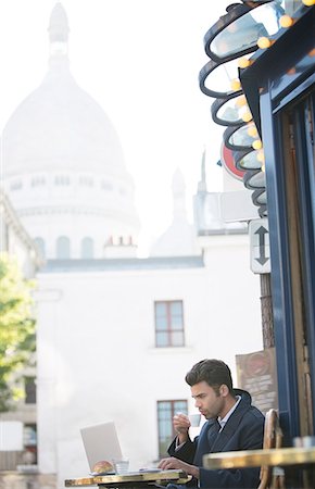 Businessman working at sidewalk cafe near Sacre Coeur Basilica, Paris, France Photographie de stock - Premium Libres de Droits, Code: 6113-07543487