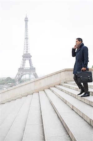 simsearch:6113-07565854,k - Businessman talking on cell phone on steps near Eiffel Tower, Paris, France Stock Photo - Premium Royalty-Free, Code: 6113-07543432