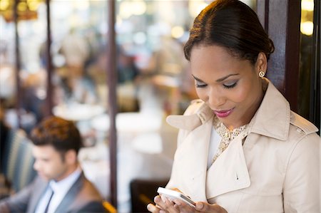 Businesswoman using cell phone at sidewalk cafe Foto de stock - Sin royalties Premium, Código: 6113-07543436