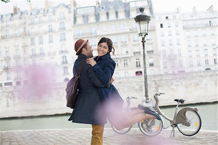 smile woman urban europe - Couple hugging along Seine River, Paris, France Stock Photo - Premium Royalty-Free, Code: 6113-07543572