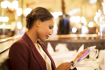 Businesswoman using digital tablet in restaurant Stock Photo - Premium Royalty-Free, Code: 6113-07543505