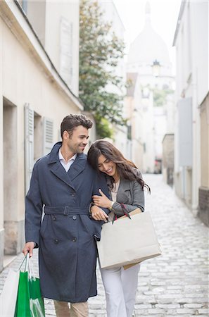 europe couple traveling - Couple carrying shopping bags on cobblestone street near Sacre Coeur Basilica, Paris, France Foto de stock - Sin royalties Premium, Código: 6113-07543640