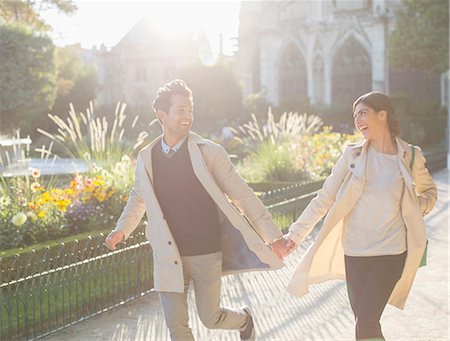enjoying sunshine - Couple holding hands and running in urban park Stock Photo - Premium Royalty-Free, Code: 6113-07543671