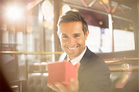 surprise box - Well-dressed man holding jewelry box in restaurant Stock Photo - Premium Royalty-Free, Code: 6113-07543615