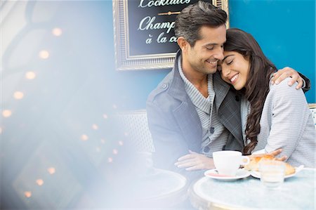 Couple hugging at sidewalk cafe in Paris, France Stock Photo - Premium Royalty-Free, Code: 6113-07543638