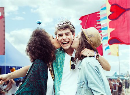 Women kissing man's cheek at music festival Foto de stock - Sin royalties Premium, Código: 6113-07564749