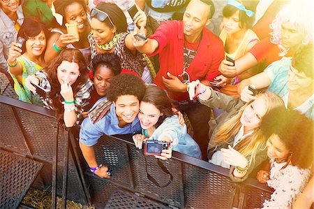 Couple taking self-portrait with camera phone at music festival Photographie de stock - Premium Libres de Droits, Code: 6113-07564788