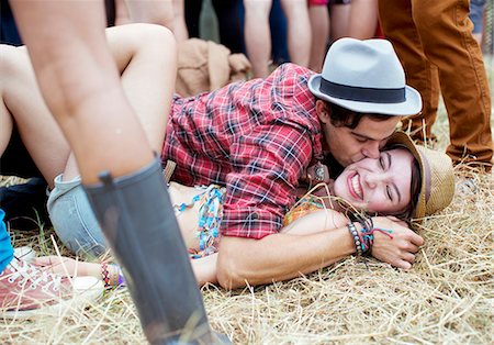 simsearch:6113-07564730,k - Couple kissing in grass at music festival Foto de stock - Sin royalties Premium, Código: 6113-07564840