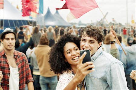 smile happy - Couple taking self-portrait with camera phone at music festival Stock Photo - Premium Royalty-Free, Code: 6113-07564857