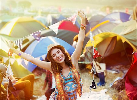 Portrait of enthusiastic woman outside tents at music festival Photographie de stock - Premium Libres de Droits, Code: 6113-07564880