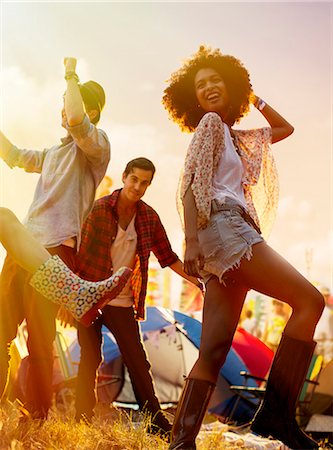 exuberant woman in sunlight - Friends dancing outside tents at music festival Stock Photo - Premium Royalty-Free, Code: 6113-07564891