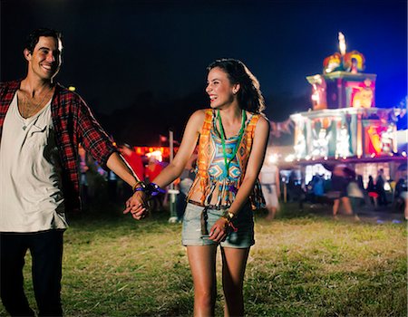 Couple holding hands and leaving music festival Stock Photo - Premium Royalty-Free, Code: 6113-07564896