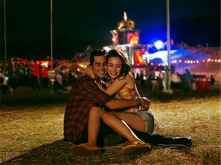 simsearch:6113-07790193,k - Happy couple hugging outside music festival Foto de stock - Sin royalties Premium, Código: 6113-07564802