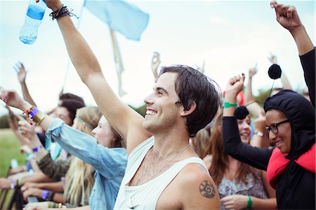 simsearch:6113-07566000,k - Man with water bottle cheering at music festival Foto de stock - Royalty Free Premium, Número: 6113-07564827