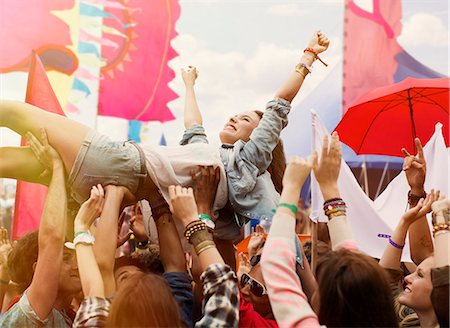 Woman crowd surfing at music festival Stock Photo - Premium Royalty-Free, Code: 6113-07564839