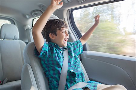 Enthusiastic boy cheering in back seat of car Stock Photo - Premium Royalty-Free, Code: 6113-07564944