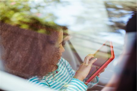 pic of a girl inside a car - Girl using digital tablet in back seat of car Foto de stock - Sin royalties Premium, Código: 6113-07564989