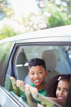 Portrait of happy brother and sister leaning out car window Stock Photo - Premium Royalty-Free, Code: 6113-07564992